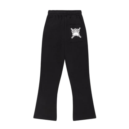 Black flared jogger with an elastic waistband and a white graphic print of a crown on a crossbones on the upper right hip, shown against a light gray background.